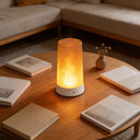 LED simulated flame table lamp glowing on a wooden table beside open books