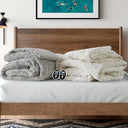 Grey heated comforter folded at the foot of a made bed