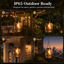 Bronze solar hanging lantern shown charging by day and glowing with a warm flickering flame at night