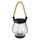 The solar flame lantern unlit on a plain background, showing its frosted shade and rope handle