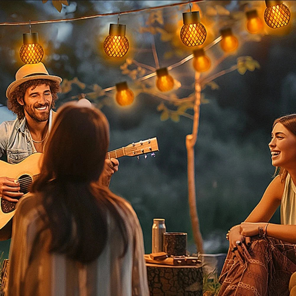 Friends gathered in a garden beneath hanging flame pendant lanterns