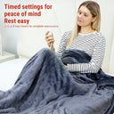 Wearable heated blanket in use with the timer control in hand