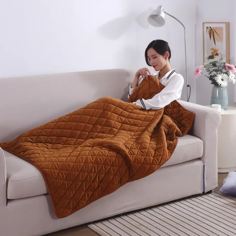 Brown quilted USB heated lap blanket on a sofa