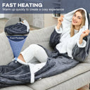 Hooded wearable heated blanket with foot pockets in use on a sofa