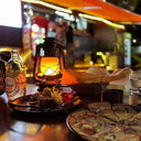 The flame lantern lighting a restaurant table set with food
